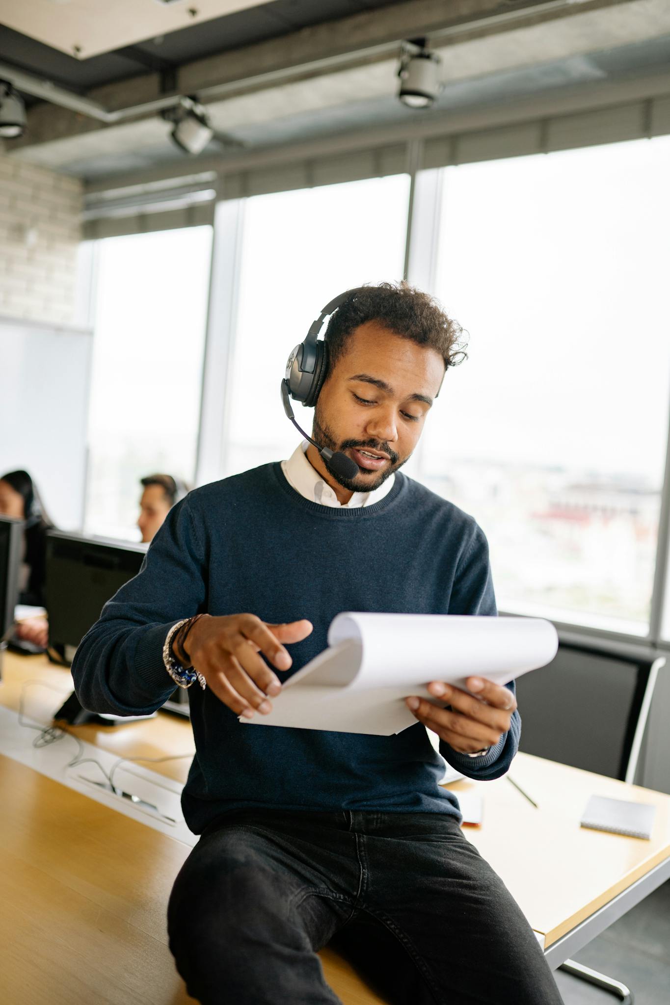 Focused man working in modern call center office with headset.
